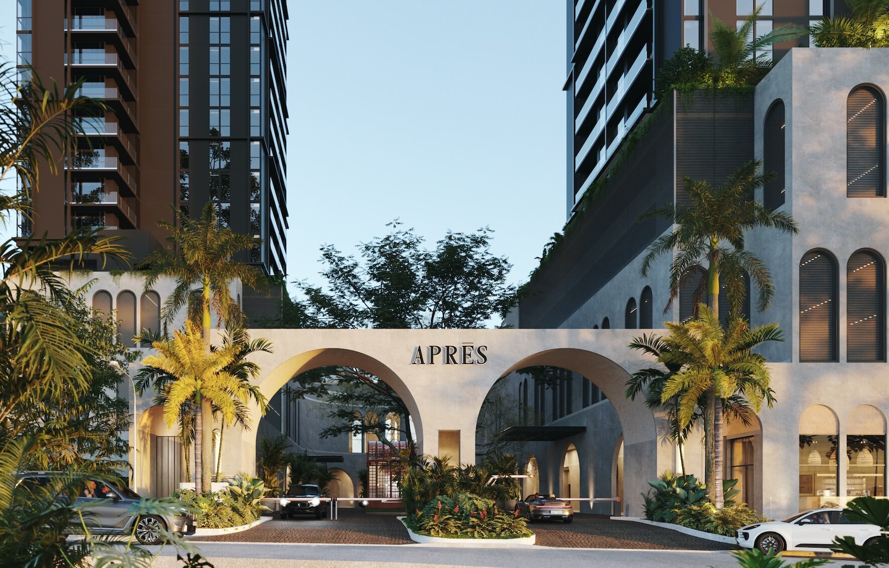 Fachada de acceso del proyecto Après con arcos, palmeras y autos estacionados.