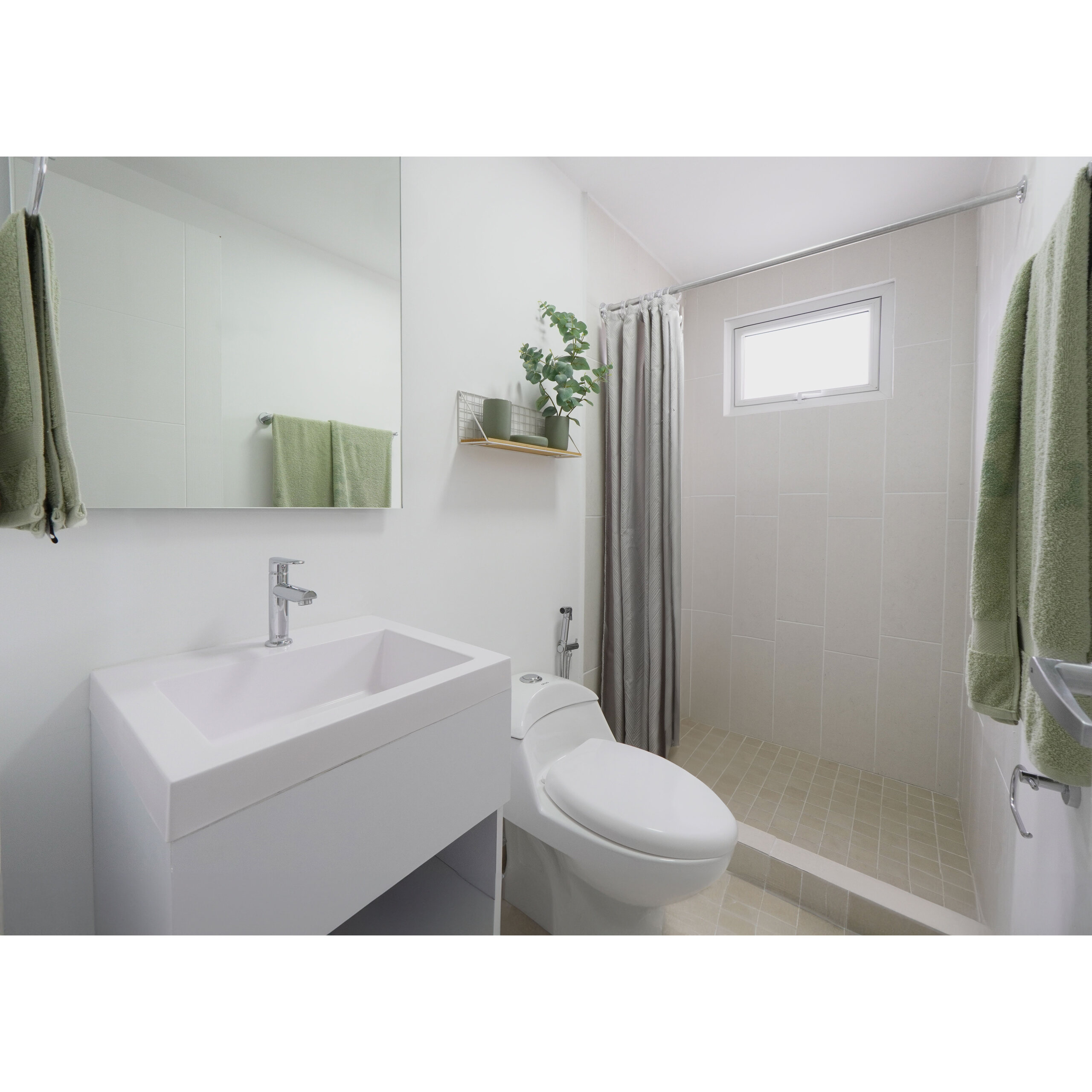 Baño moderno con ducha, lavabo, sanitario, espejo y toallas verdes.